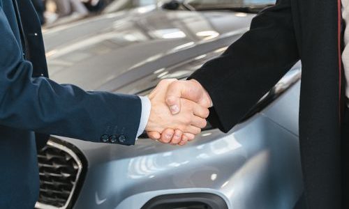 Stretta di mano tra cliente e operatore Autoberica davanti a un’auto venduta a Vicenza
