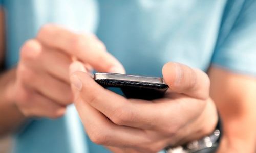 Persona che richiede informazioni per vendere un’auto usata a Vicenza tramite smartphone