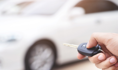 Chiave auto in primo piano davanti a veicolo usato pronto per la valutazione presso Autoberica Vicenza